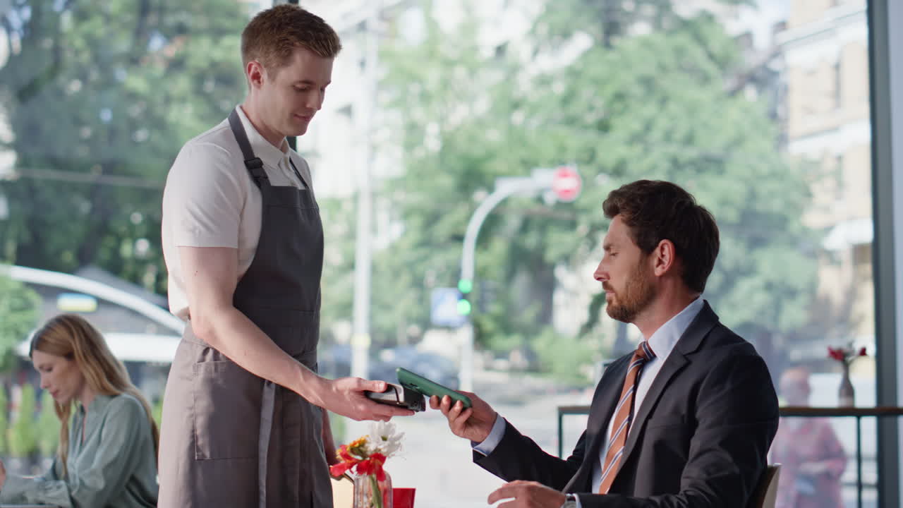 Businessman paying contanless technologies using smartphone in restaurant