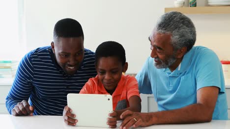 family using digital tablet in kitchen