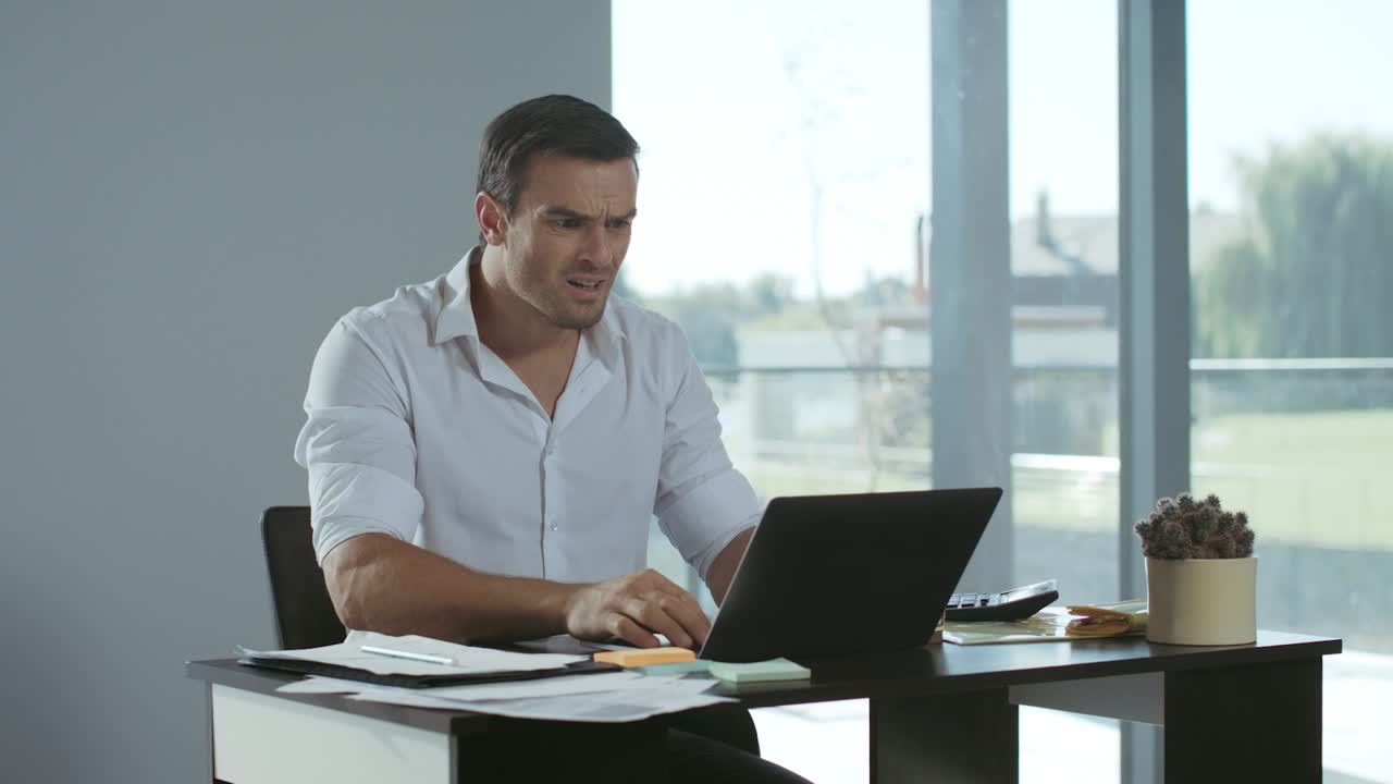 hombre de negocios recibiendo una mala carta por correo electrónico. serio freelance trabajando en una computadora portátil.
