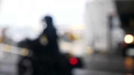 Cinematic-sequence-of-bokeh-motor-bikers-waiting-in-traffic,-industrial-background