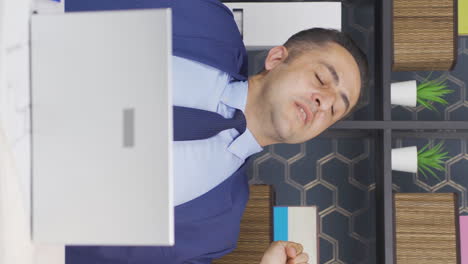 vertical video of sleepy businessman yawns looking at camera.