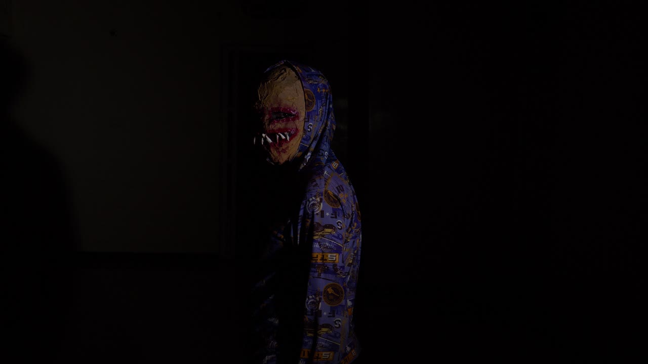 máscara facial de terror caminando hacia adelante y luego girando con sombra