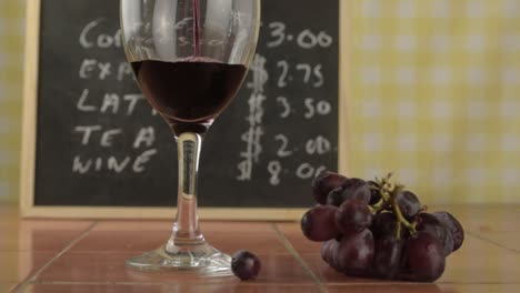 pouring red wine into a glass in cafe counter medium shot