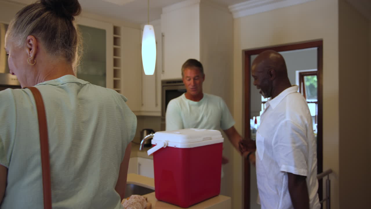 Senior woman preparing skewers in modern kitchen, smiling and chatting with friend, at home