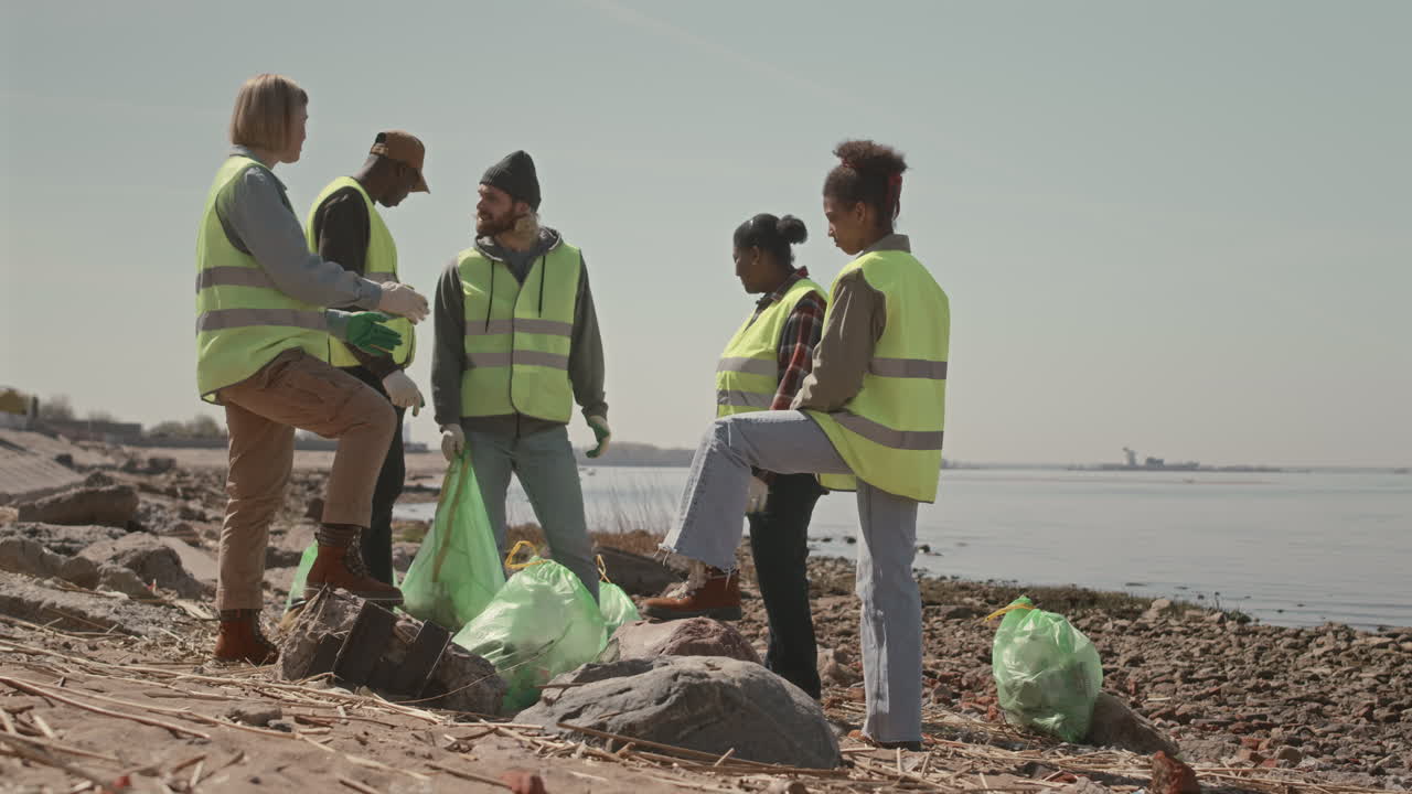 Group of Environmental Activists Discussing Shoreline Cleanup