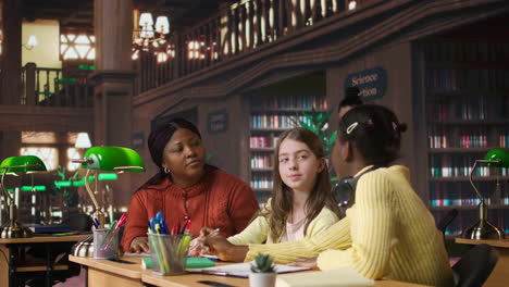 teacher assisting students in a library setting