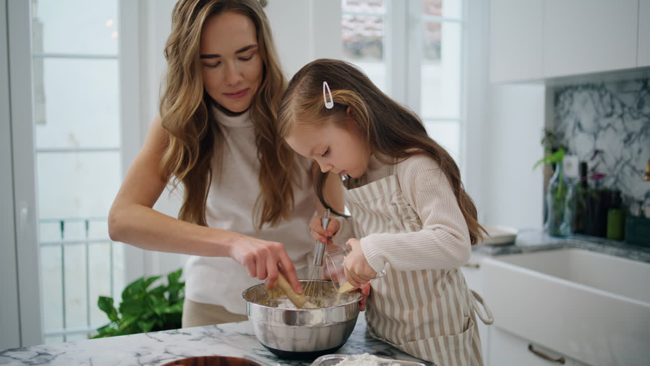Caring woman talking child at kitchen close up. Positive family creating dough