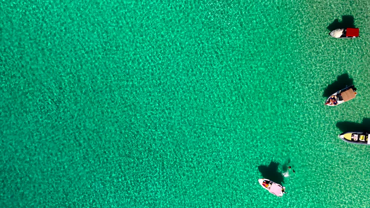 Barche galleggiano delicatamente su una splendida acqua turchese, immerse nella natura. Il sole splende luminoso, creando un'atmosfera serena e pacifica. Questo luogo è perfetto per il relax e l'avventura.