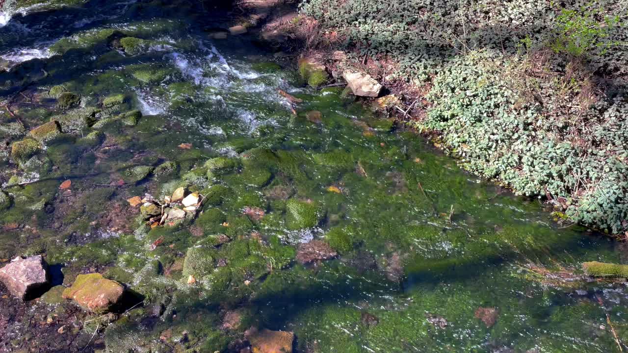 hermosa y pacífica corriente de agua que fluye a través de las rocas hasta el acuífero subterráneo
