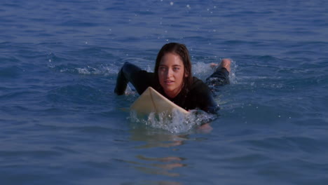 Pretty-woman-paddling-on-a-surfboard