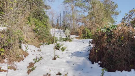 Man-walking-in-snow-on-high-mountain