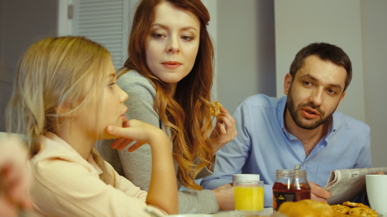 아침 식사로 잼, 쿠키, 주스, 죽을 먹는 행복한 가족