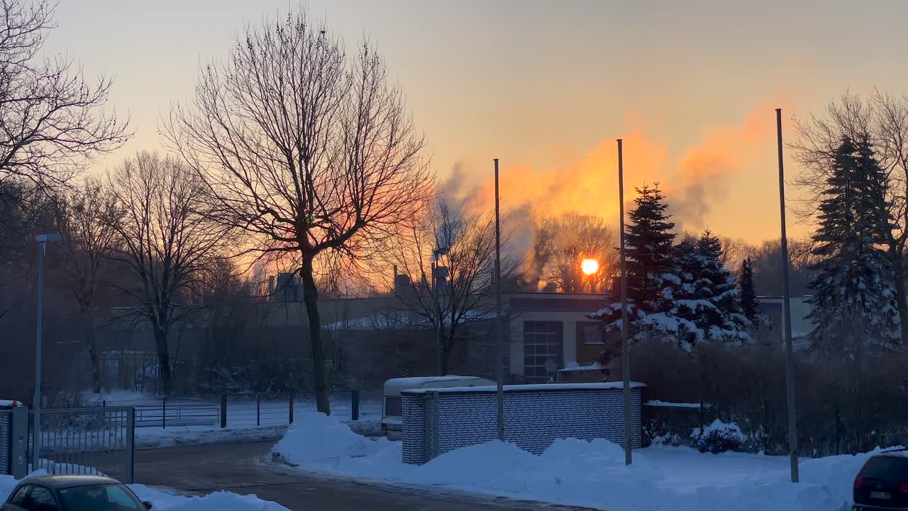 배경에 아름다운 일몰과 함께 눈으로 가득 찬 공장과 주차 공간에서 연기