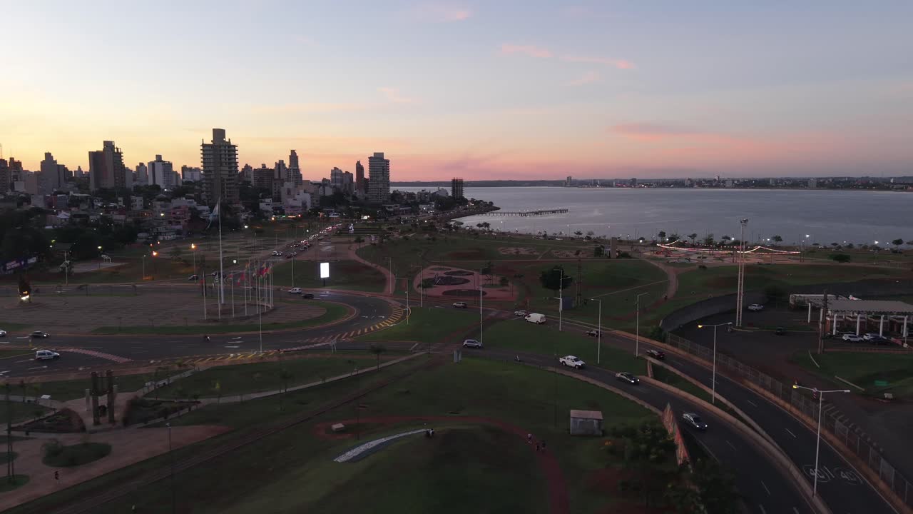 Coastal cityscape at dusk with local roads, streetlights and beautiful aerial skyline in the distance, Posadas, Misiones, Argentina.