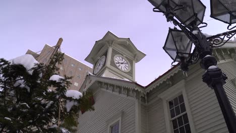 Looking-up-at-old-clock-tower-in-Sapporo-City,-Hokkaido-during-winter