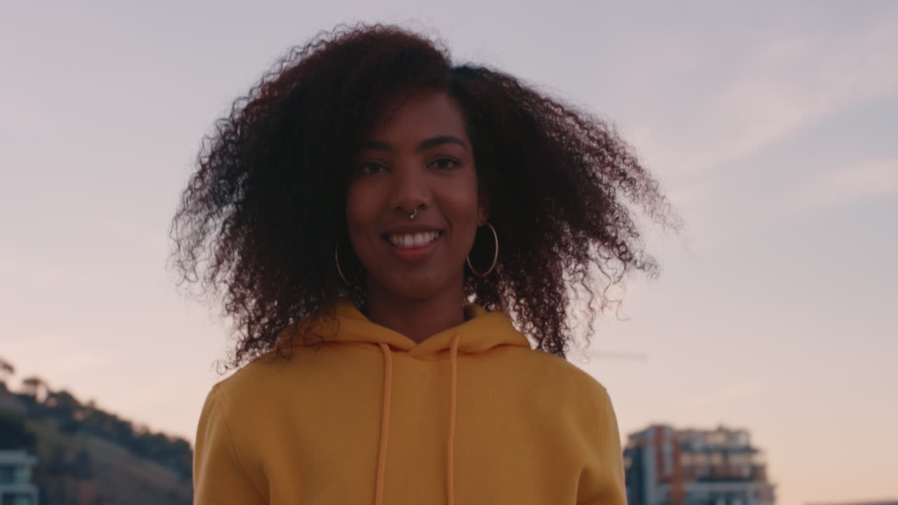retrato de una hermosa mujer afroamericana haciendo caras riendo disfrutando del estilo de vida de verano en el techo al atardecer