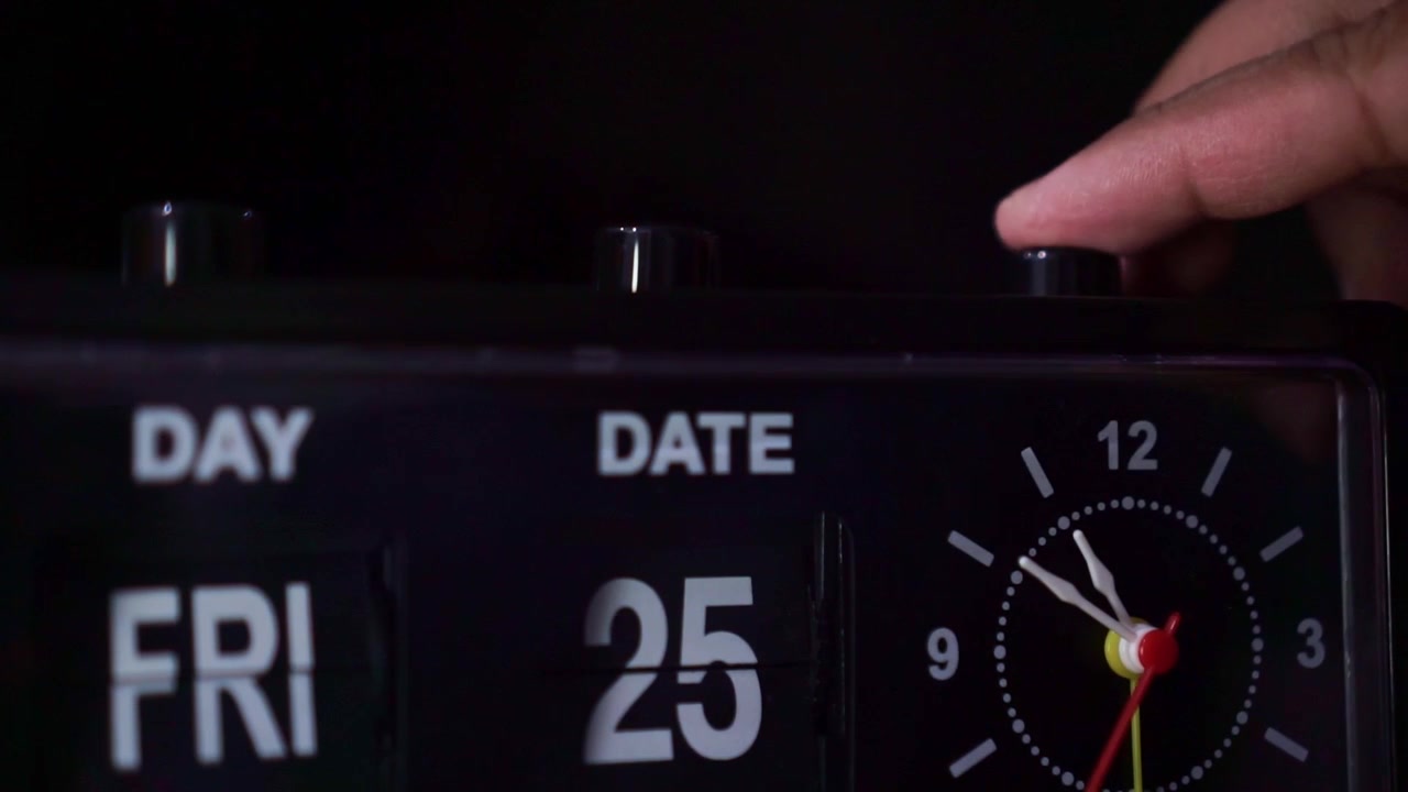hand pressing button on retro alarm clock, dark ambiance, morning wake up concept.