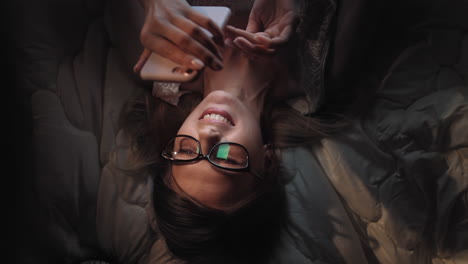 mujer usando el teléfono en la cama por la noche