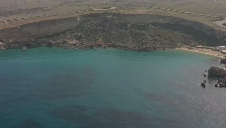 Sideways-aerial-Drone-shot-of-paradise-bay-Malta-and-rock-coastline