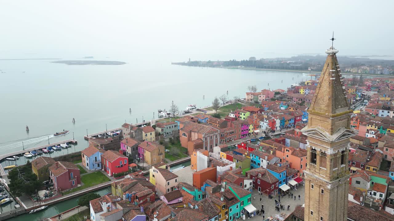 Ascending Aerial of The Church Of Saint Martin Bishop Bell Tower in Burano, An Island Province Of Venice In Italy On A Foggy Day.