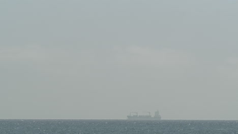 cargo ship sailing in quiet sparkling ocean