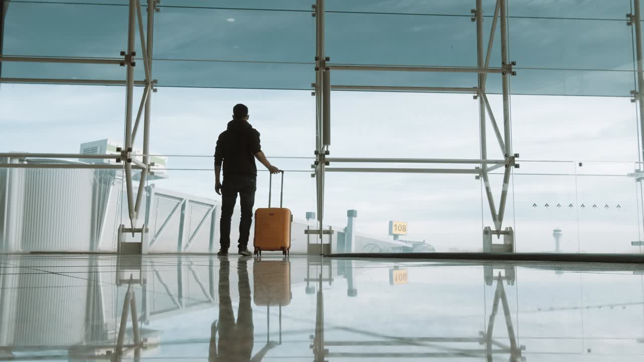 Passenger with baggage at international airport walking to terminal gate - Travel and transportation concept