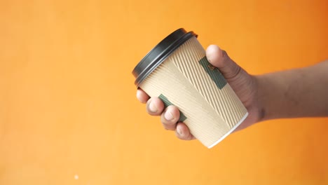 hand holding a disposable coffee cup