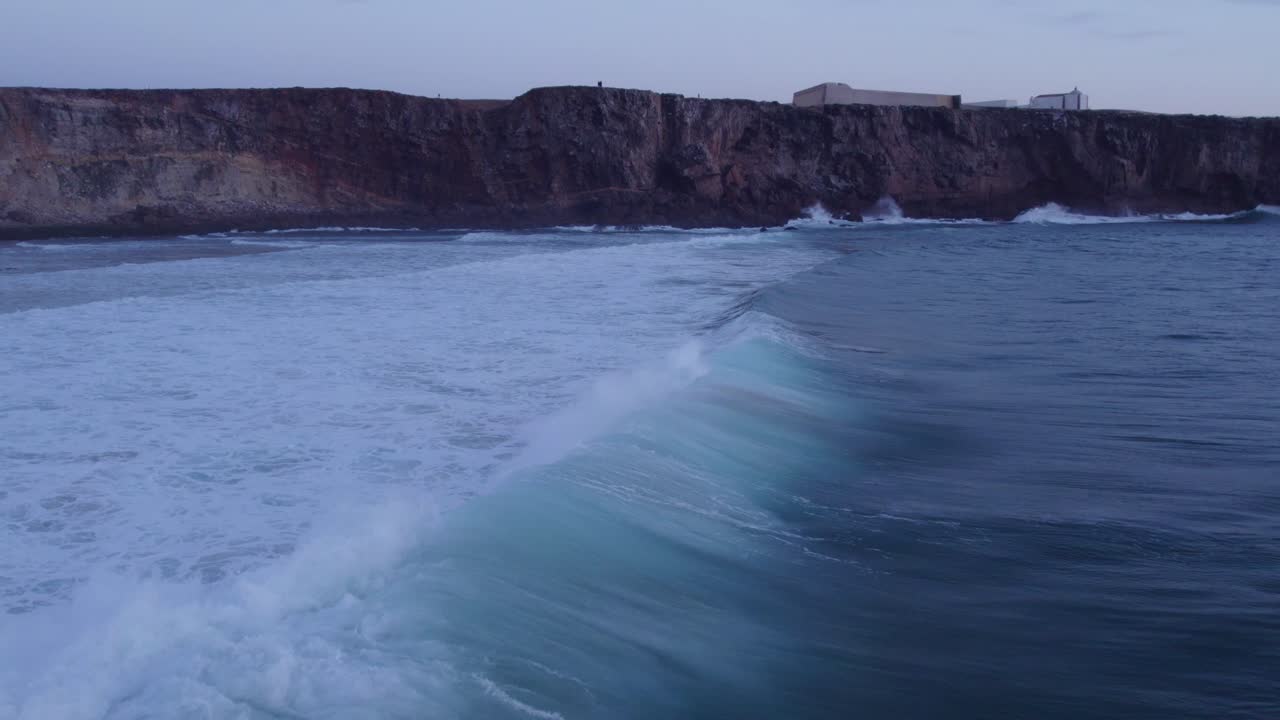 surf de olas en la playa do tonel sagres con grandes olas al atardecer en portugal, desde el aire
