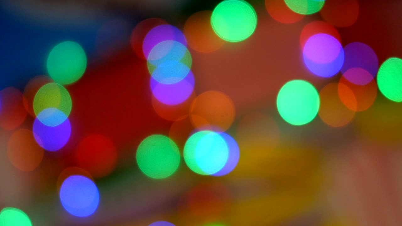 Blurred colorful lights. Red, green, yellow, orange, blue defocused glittering bokeh festive background.