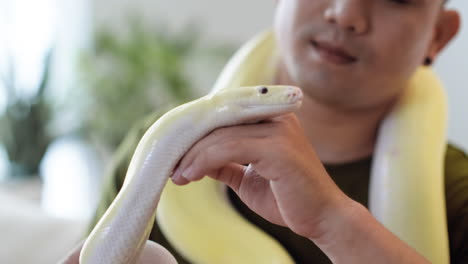 Man-holding-snake-indoors