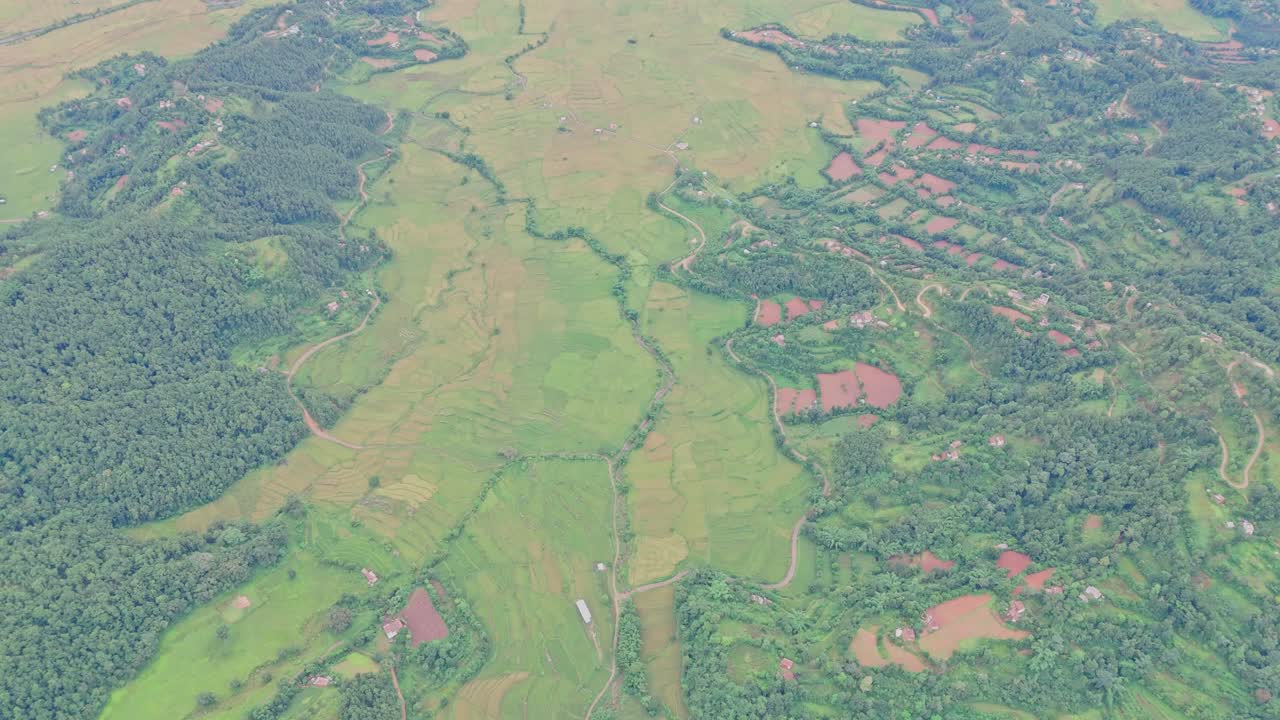 Aerial view of lush green paddy fields in Tansen Palpa, Nepal, surrounded by beautiful mountains and rural landscapes, showcasing the region’s rich agriculture and natural beauty