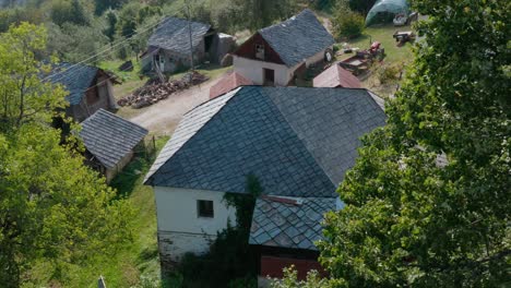 Ancient-Roofing-Made-Of-Stone-Plates-On-Old-Country-Houses---aerial-drone-shot