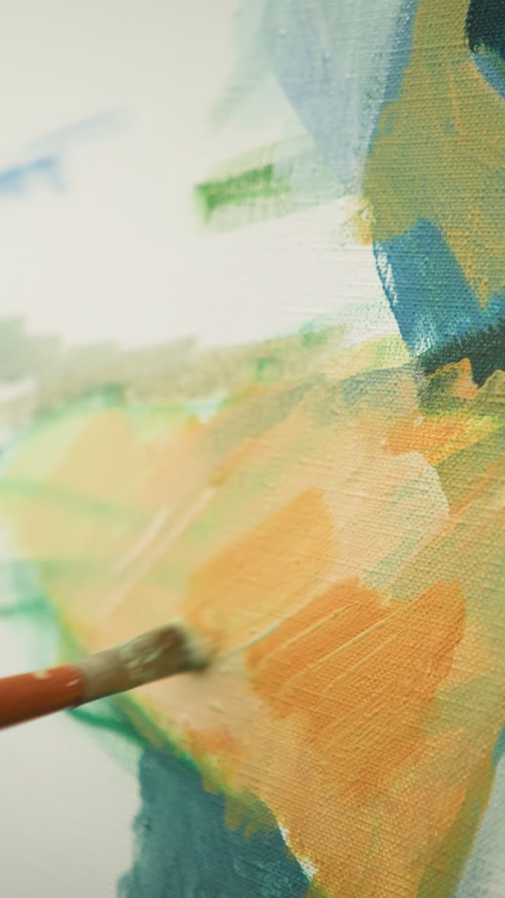 A close-up shot of an artist s hand delicately applying paint to a canvas with a small brush. highlighting the artist's technique and attention to detail