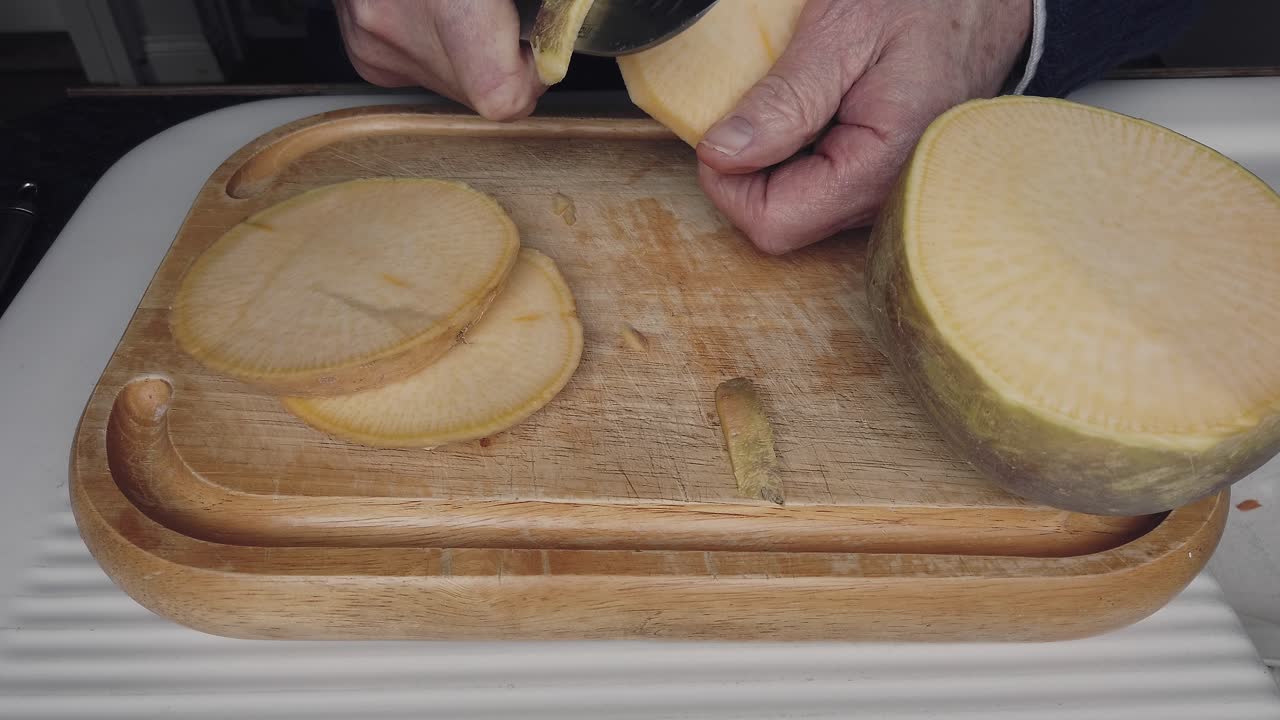 Peeling slices of swede before chopping to make a handmade root vegetable soup