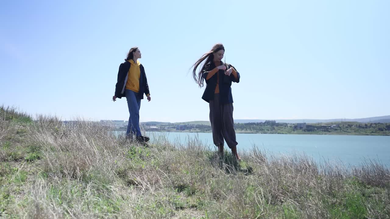 Two women on a hill near the sea