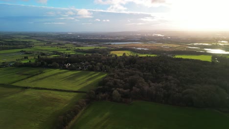 wintertime aerial drone flyover the cheshire countryside from burton, england, uk in golden hour on a sunny winter’s afternoon.