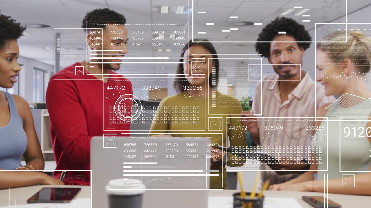 Coworkers standing around laptop, tablet tapping activating HUD overlays highlighting business data