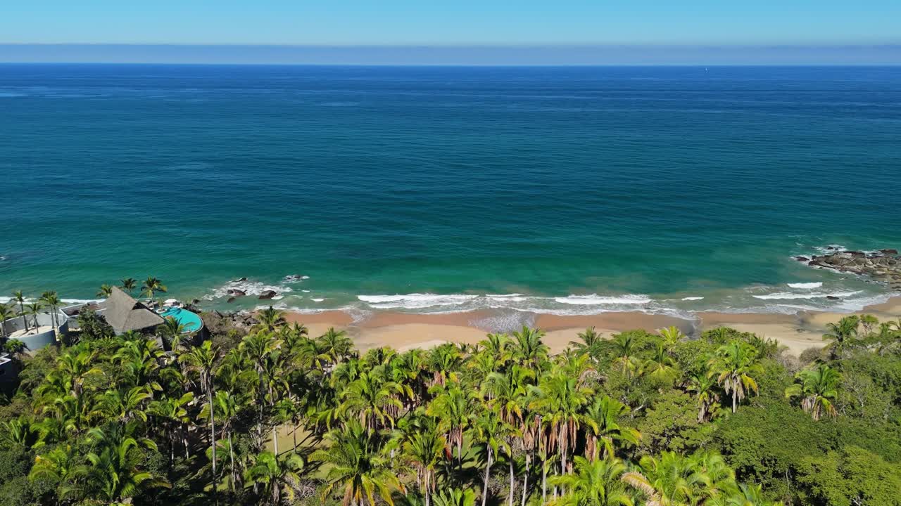 Drone voando sobre palmeiras em uma praia escondida no México