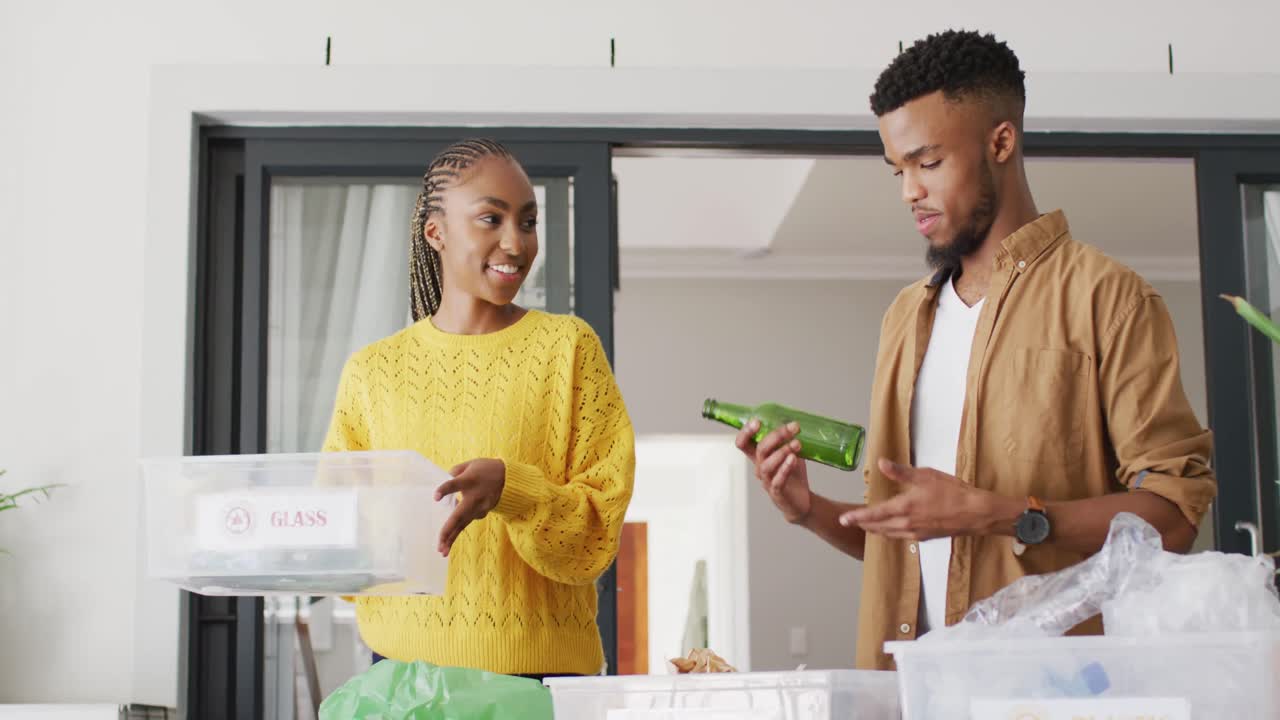Joyeux couple afro-américain recyclant des déchets