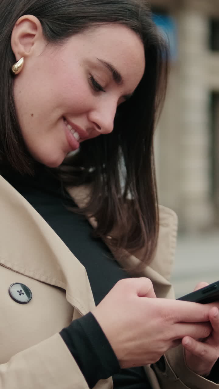 Giovane donna sorridente che usa lo smartphone all'aperto