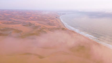 Buena-Toma-Aérea-Alta-A-Través-De-Las-Nubes-Y-La-Niebla-Sobre-Las-Vastas-Dunas-De-Arena-Del-Desierto-De-Namib-A-Lo-Largo-De-La-Costa-De-Los-Esqueletos-De-Namibia