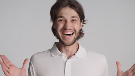 caucasian surprised man in front of camera on gray background.