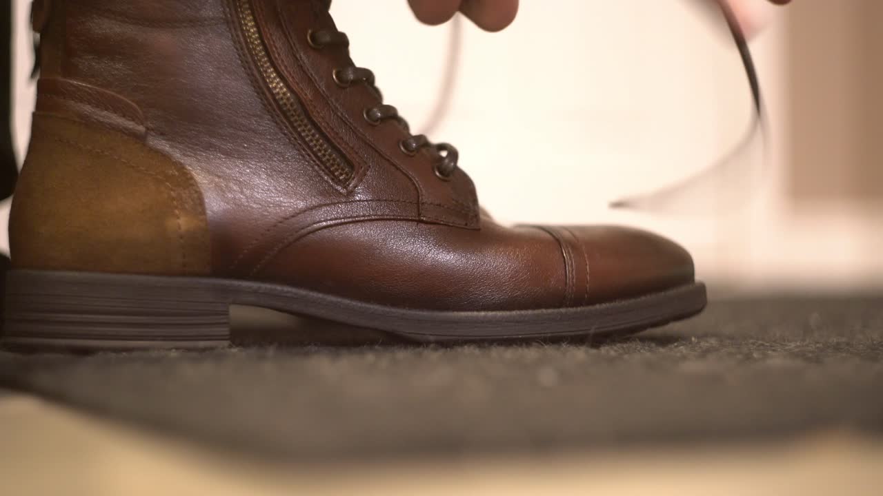 Zipping and tying brown leather boots shoes and trying on shoes from online shopping