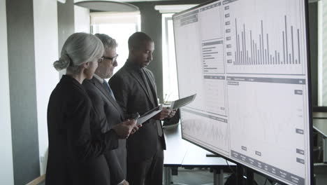 business traders on a meeting room with data on screen