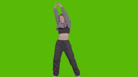 studio shot of young woman having fun dancing against green screen 32