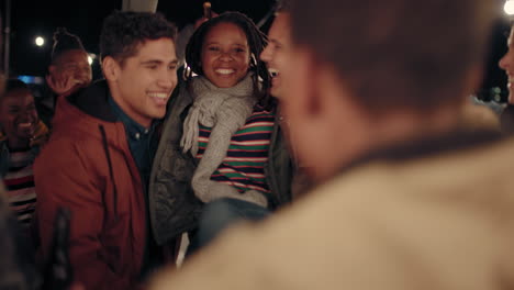 young group of multiracial friends having fun dancing playfully together enjoying rooftop party at night laughing celebrating friendship