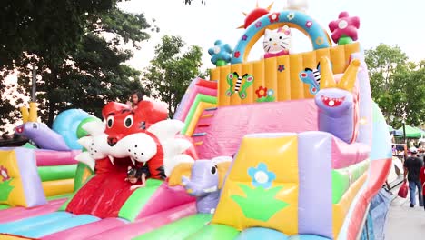 children playing on colorful inflatable slide