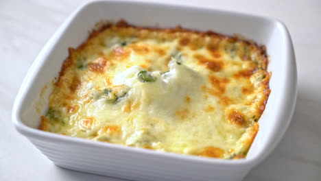 Lasaña de espinacas al horno con queso en placa blanca.