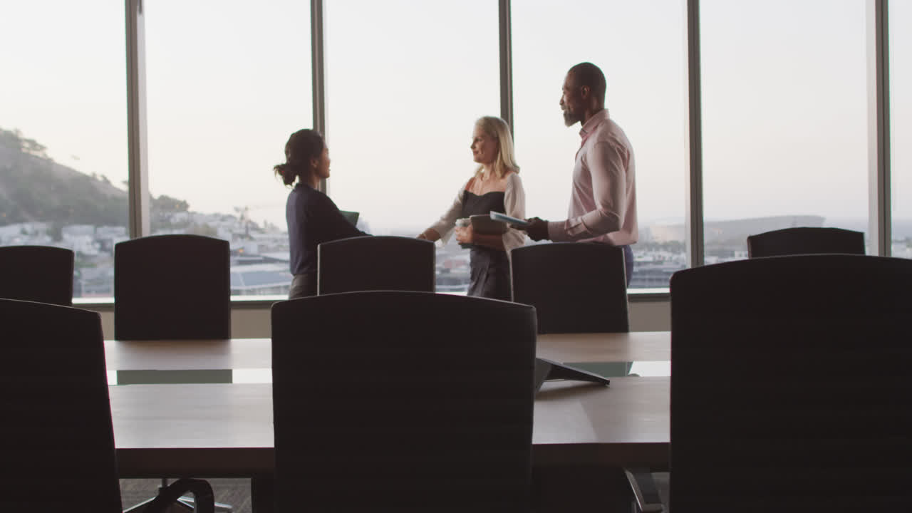 Professional businesspeople shaking hands in modern office in slow motion