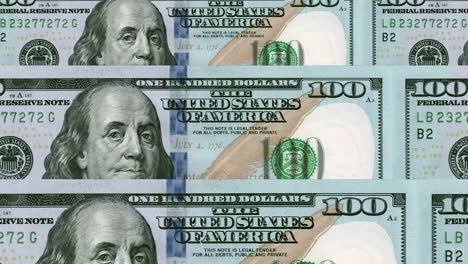 a close-up camera shot panning across multiple united states of america 100 dollar bills - seamless looping